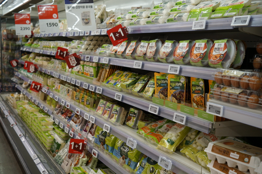 사진 설명 시작. 대형마트 냉장고 가판대에 초록색으로 포장된 가공식품들이 줄지어 진열돼 있다. 사진 설명 끝.