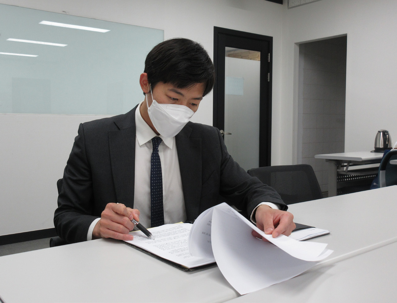 사진설명 시작. 손명호 변호사가 사무실에서 헌법재판소의 교섭창구 단일화 제도 판결 관련 자료를 보고 있다. 사진 설명 끝.