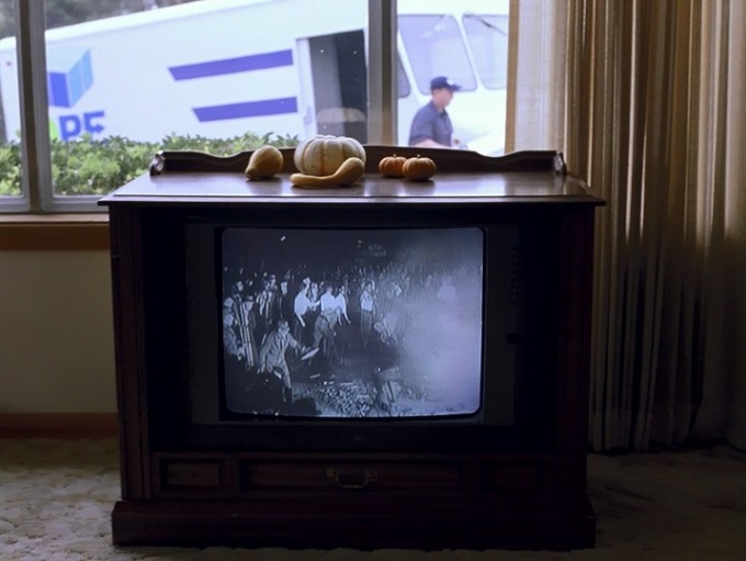 사진3 알렉스는 나치에 관한 다큐멘터리를 본다. 에릭이 무얼 보냐고 묻자 알렉스는 자기도 모른다고 대답한다. 창밖에는 택배차가 도착한다. 인터넷으로 주문한 총기가 배송된다..jpg