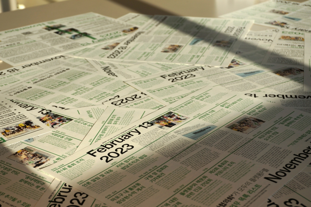 사진 설명 시작. 플랫폼P 개편 선언에 대한 입주사 공동 대응 타임라인을 신문 형식으로 구성한 종이가 어지러이 놓여 있다. 가장 위에는