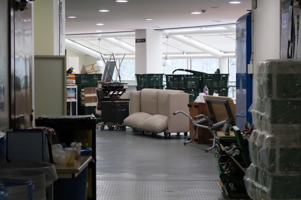 16동 복도의 풍경. 의자, 책상, 책꽂이 등 다양한 가구와 상자들이 어지럽게 쌓여 있다. 사진 설명 끝.