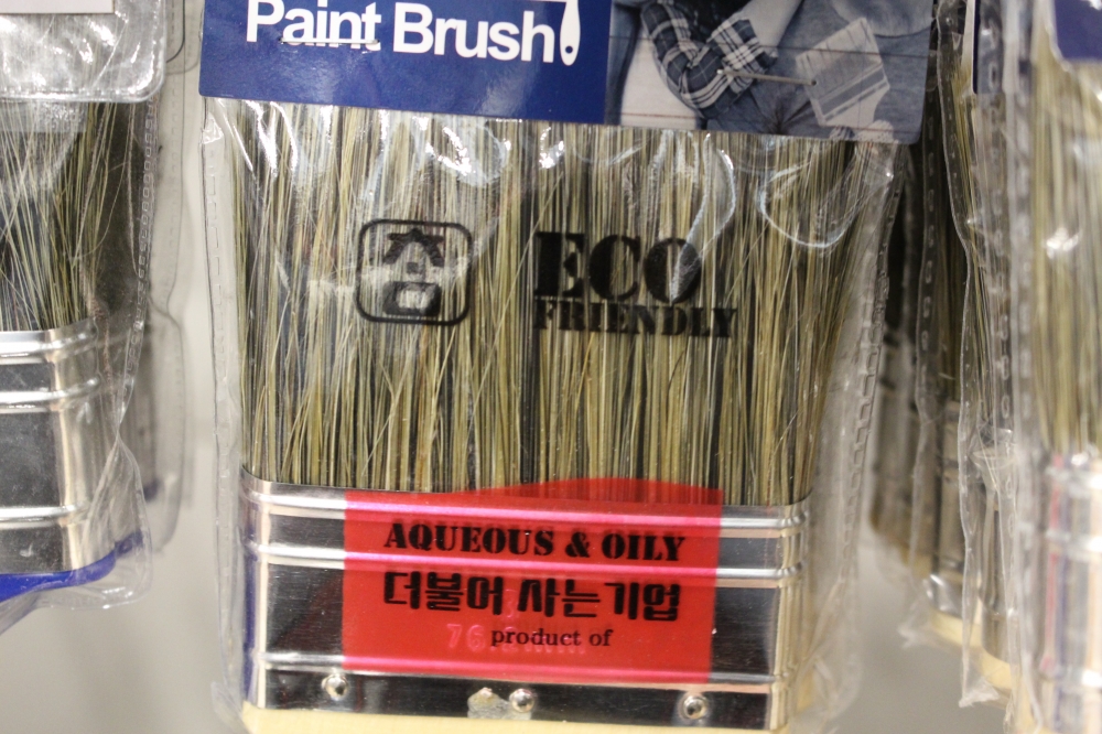 사진 설명 시작. 옅은 짚색과 검은색이 섞인 빳빳한 털을 가진 페인트붓이다. 페인트붓을 감싼 포장지 정면에 ‘친환경적(eco-friendly)’라는 표현이 사용됐다. 사진 설명 끝.