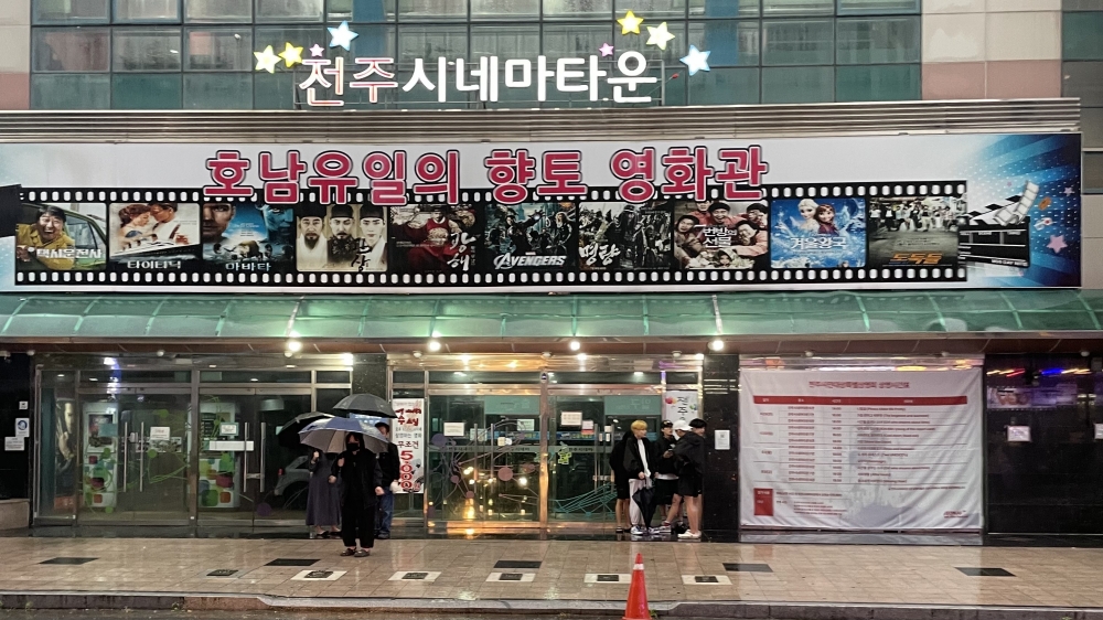 사진 설명 시작. 전주시네마타운 건물 앞. 호남유일의 향토 영화관이라는 문구가 빨갛게 써있다. 사진 설명 끝