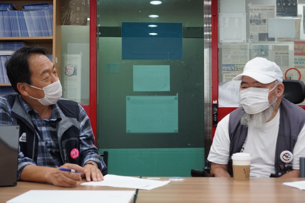 사진 설명 시작. 천성호 교장과 김명학 교장이 서로를 마주본 채 이야기를 나누고 있다. 사진 설명 끝.