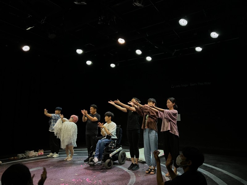 사진 설명 시작. 연극 《여기, 한때, 가가》의 커튼콜. 장애인, 여성 등 다양한 배우들이 무대 위에 올라와 관객들에게 인사를 하고 있다. 사진 설명 끝.