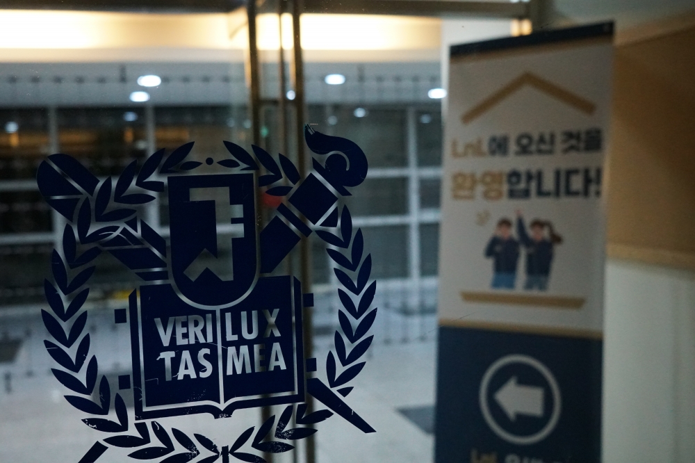 사진설명 시작. 서울대학교 로고가 붙어있는 창 뒤로