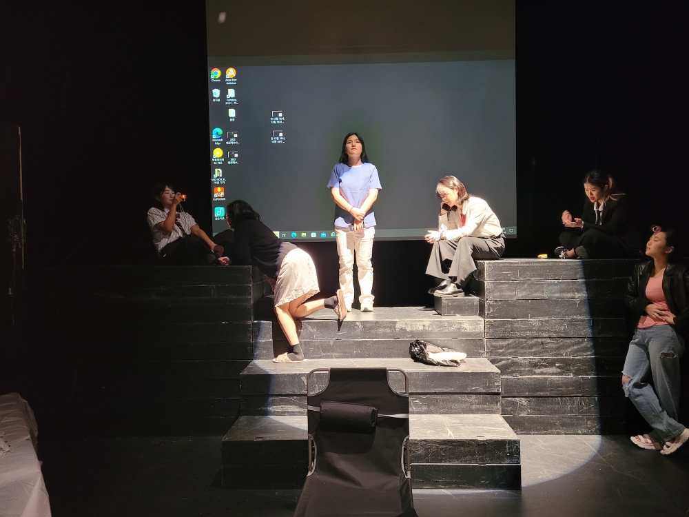 사진 설명 시작. 영문극회 배우들이 무대에 올라가 있다. 사진 설명 끝.