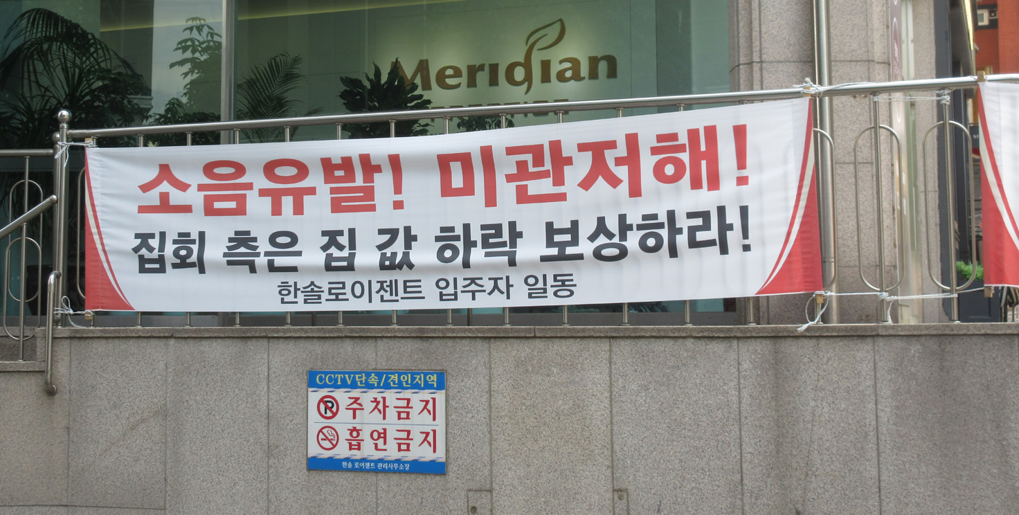 사진 설명 시작. 농성장 근처 아파트에서 내건 현수막. 소음유발! 미관저해! 집회 측은 집값 하락 보상하라! 라는 문구가 적혀있다. 사진 설명 끝.