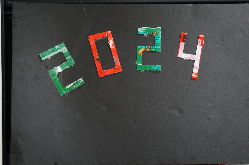 사진 설명 시작. 검은 골판지 위에 과자 상자로 만든 숫자를 붙였다. 숫자는