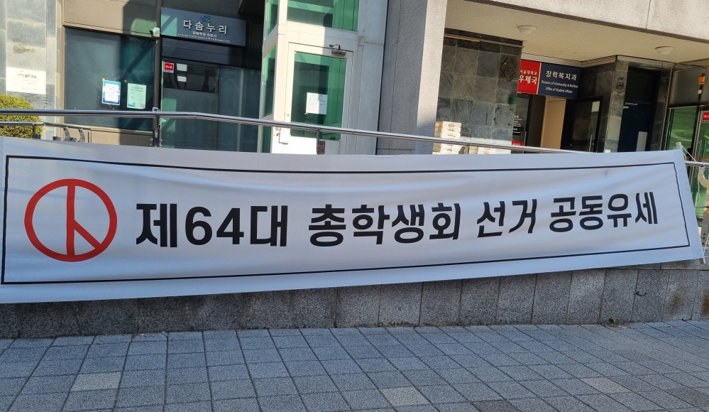 사진 설명 시작. 제64대 총학생회 선거 공동유세라 적힌 하얀 플랜카드 사진이다. 사진 설명 끝.