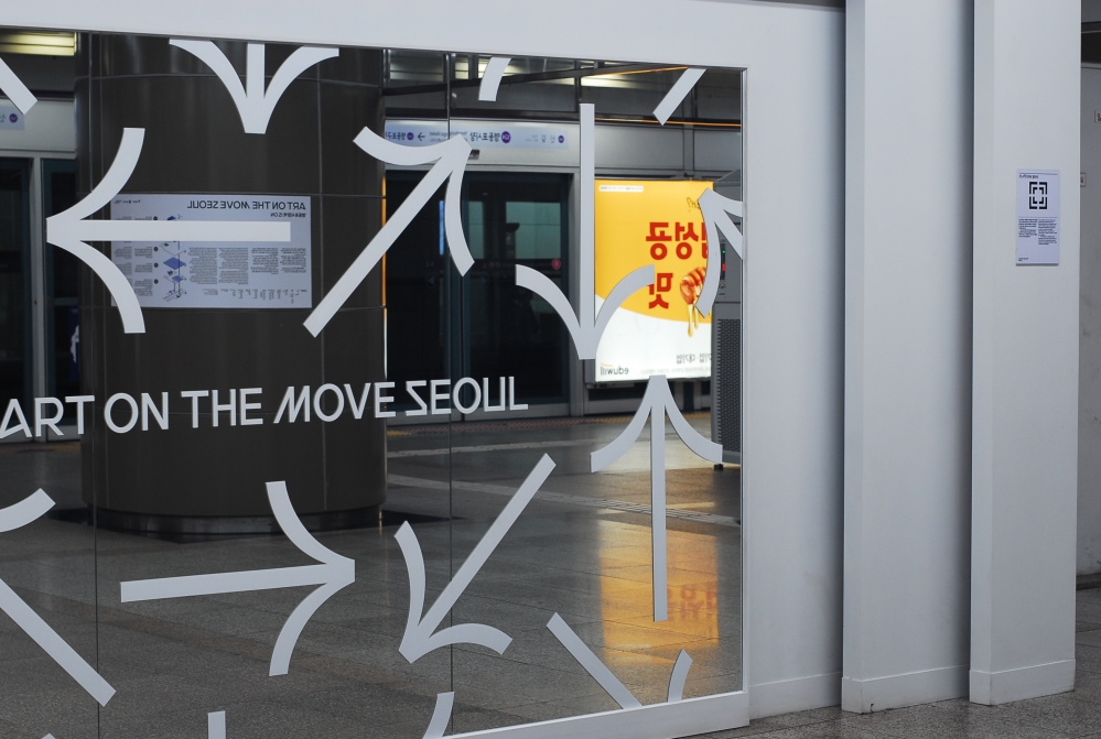 사진 설명 시작. 승강장 한편에 큰 거울이 설치돼 있다. 지하철을 이용하는 시민들의 모습을 담아 ‘움직이는 작품(Art on the Move)’을 만드는 설치작품 ‘빅 미러’(Big Mirror)다. 그러나 이 작품에는 자꾸만 반대편의 상업광고가 반사돼 담긴다. 사진 설명 끝.