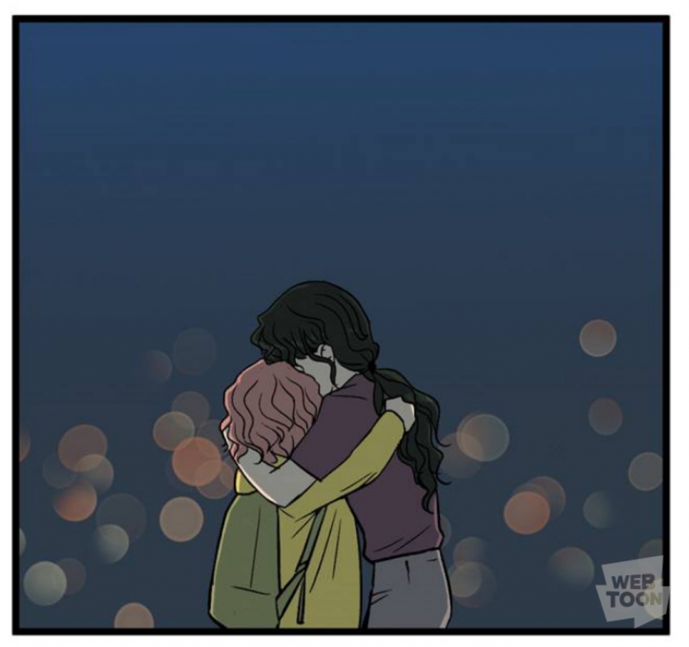 사진 설명 시작. 은은한 불빛만 감도는 어두운 남색 배경, 검은 파마 머리를 묶고 보라색 티를 입은 마리의 고모와 핑크색 곱슬 단발머리에 노란색 옷을 입고 책가방을 멘 마리가 서로를 꼭 마주 껴안고 있다. 사진 설명 끝.