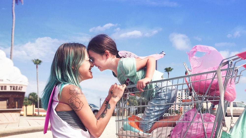 사진 설명 시작. 무니가 쇼핑 카트에 올라 타 있다. 핼리는 쇼핑 카트에 손을 얹고 무니와 얼굴을 맞대면서 미소를 짓는다. 사진 설명 끝.