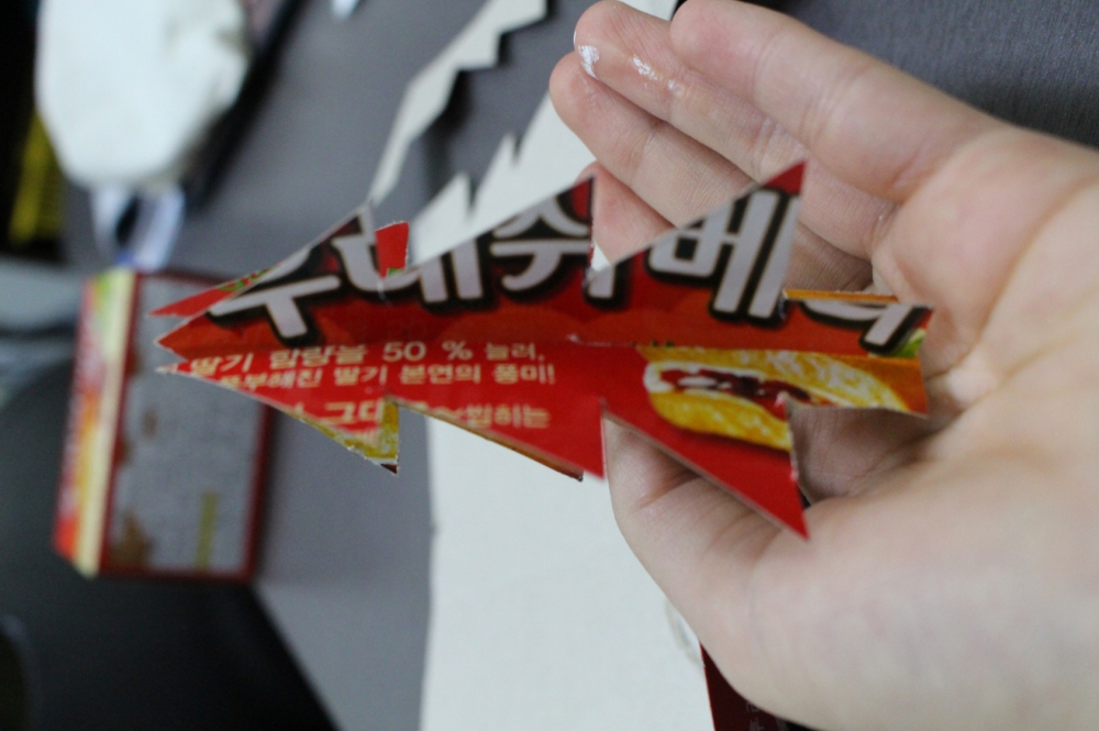 사진 설명 시작. 두 모양을 홈을 서로 끼워넣어 합쳐 입체 크리스마스트리 장식을 만들어 손에 올렸다. 사진 설명 끝.