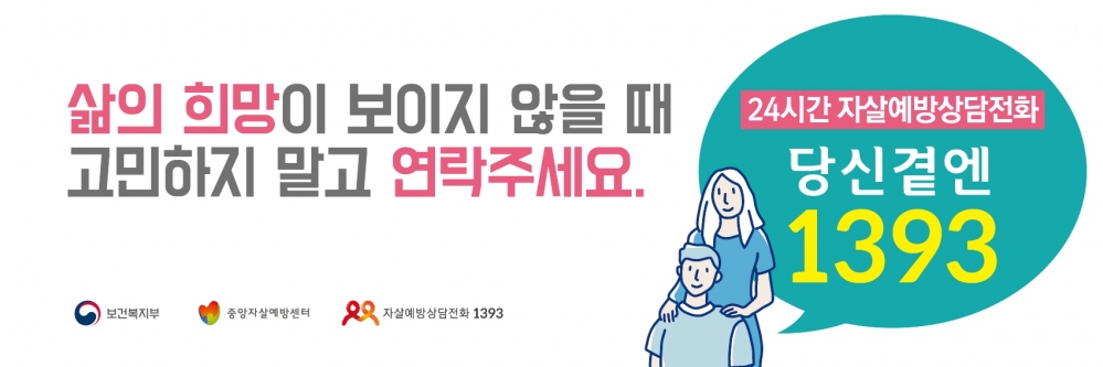 사진 설명 시작. 화면 중앙에 큰 글씨로 ‘삶의 희망이 보이지 않을 때 고민하지 말고 연락주세요.’라는 문구가 써있다. 문구 오른쪽에는 앞뒤로 서 있으며 뒷사람이 앞사람의 어깨에 손을 올리고 있는 두 사람의 모습이 있다. 두 사람의 모습 뒤로 커다란 푸른색 말풍선이 있는데, 말풍선 안에는 ‘24시간 자살예방상담전화 당신곁엔 1393’라 써있다. 사진 설명 끝.