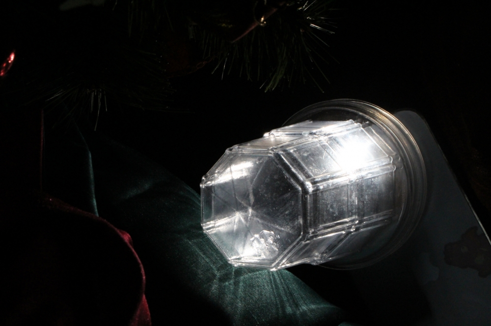 사진 설명 시작. 아이스크림 뚜껑 안에 놓인 핸드폰에서 빛이 나고 있다. 사진 설명 끝.