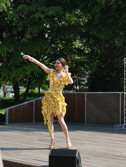 사진 설명 시작. 초대가수가 오른손으로 마이크를 높이 들고 관객의 호응을 유도하고 있다. 사진 설명 끝.