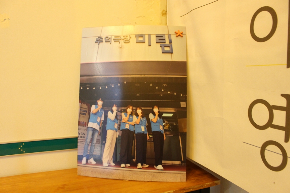 사진 설명 시작. 파란색 조끼와 명찰을 건 5명의 학생이