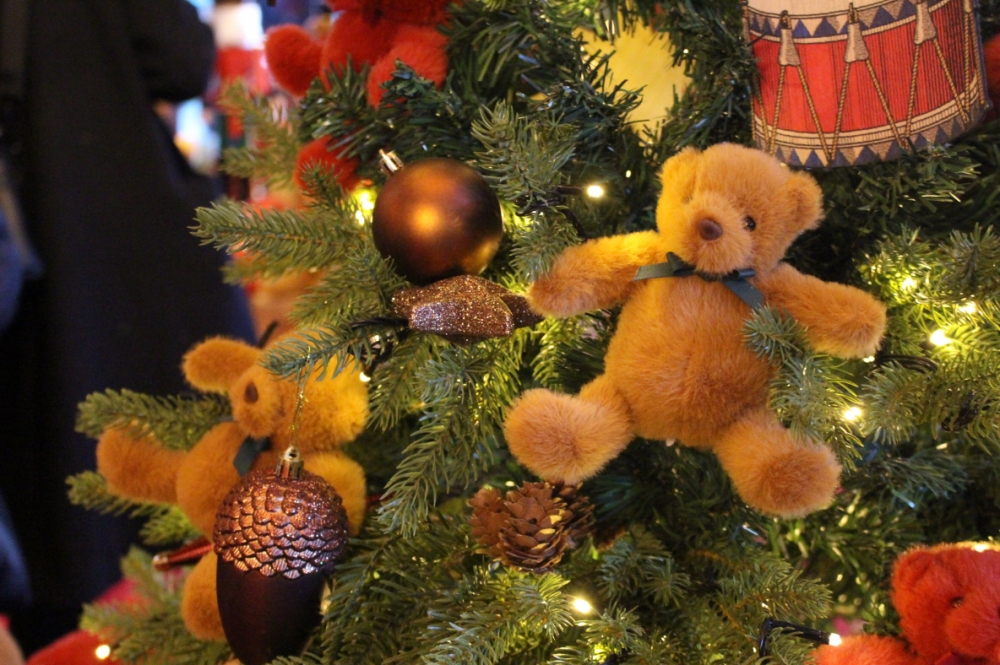 사진 설명 시작. 반짝이로 끝부분이 장식된 도토리 장식이 곰돌이 장식과 더불어 트리에 매달려있다. 사진 설명 끝.