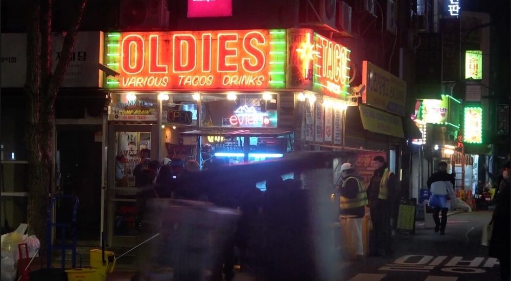 사진 설명 시작. 어두운 밤의 거리를 찍은 사진이다. 사진 정중앙에