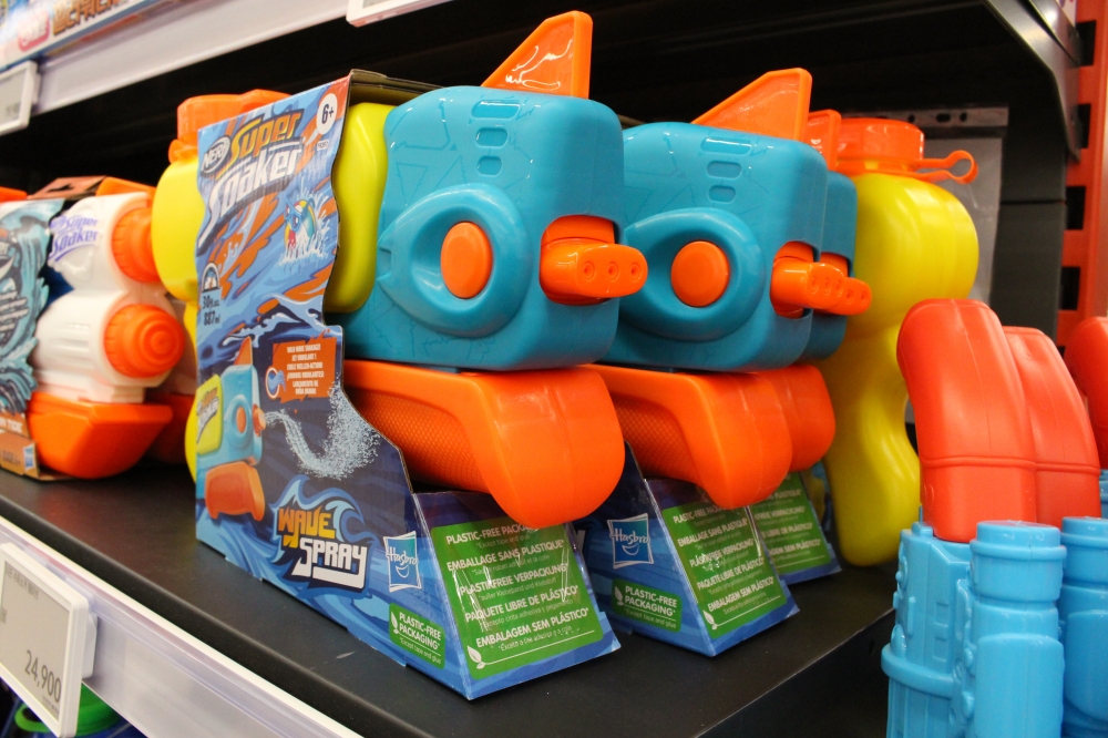 사진 설명 시작. 노랑, 녹색, 주황 등 다채로운 색으로 이루어진 물총이 포장되어 있다.