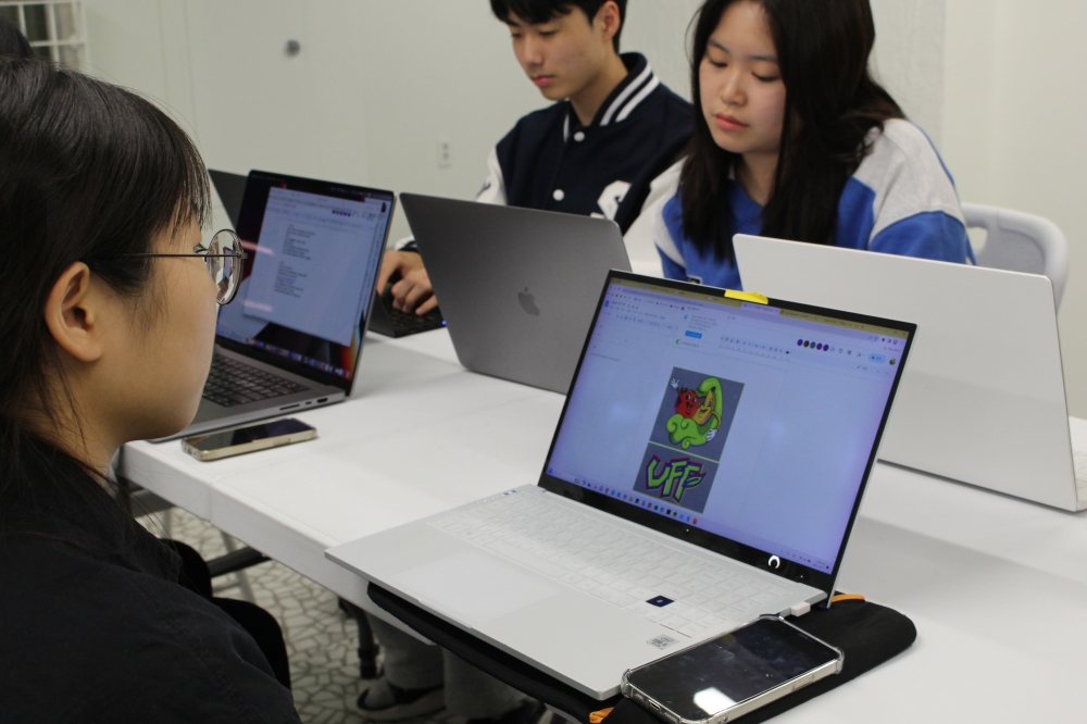 사진 설명 시작. 한 학생이 컴퓨터로 자료를 찾아보고 있다. 모니터에 과일 이미지가 보인다. 사진 설명 끝.