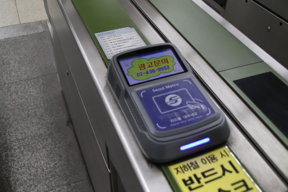 사진 설명 시작. 광고 대행업체를 홍보하는 광고다. ‘광고문의’라는 문구가 적힌 대행업체 광고는 교통카드를 찍는 개찰구의 LCD 화면에 띄워져 있다. 사진 설명 끝.