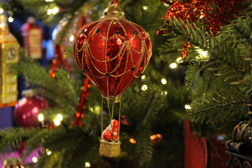사진 설명 시작. 산타가 탄 빨간색 열기구 크리스마스 장식이 트리에 달려있다. 사진 설명 끝.