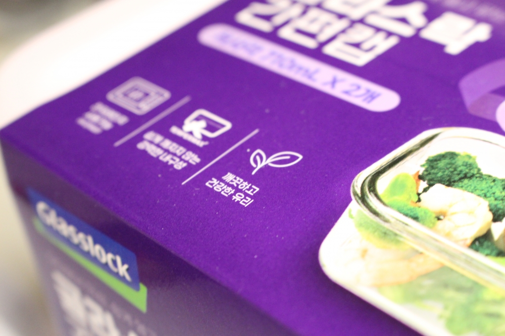 사진 설명 시작. 투명한 밀폐용기의 보라색 포장지가 크게 확대돼 있다. 포장 왼쪽 하단의 제품 설명 문구 중