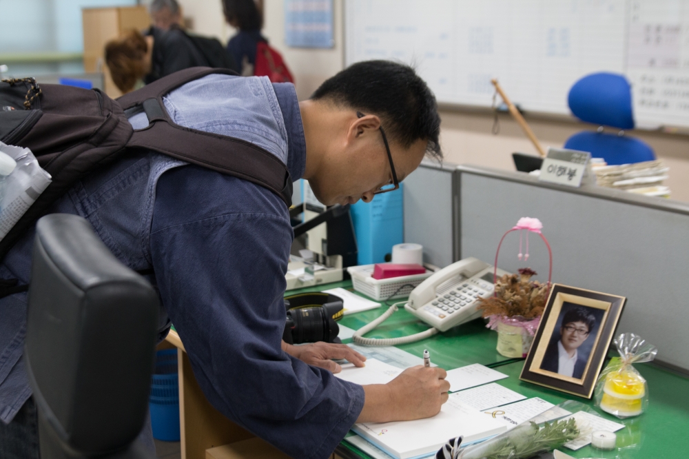 5-5.희생된 교사에게 추모글을 남기는 전교조 교사.jpg