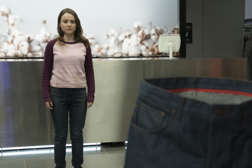 사진 설명 시작. 티셔츠에 청바지를 입은 리비가 살인 청바지를 바라보고 있다. 청바지는 입는 모양 그대로 서 있지만 안은 텅 비어있다. 사진 설명 끝.