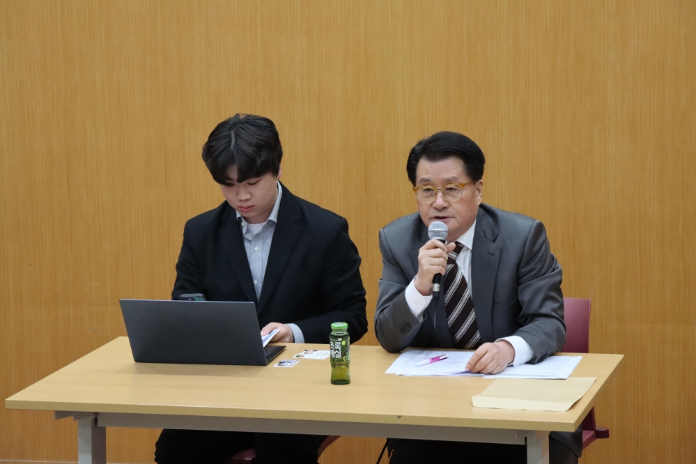 사진설명 시작. 유종필 후보가 청중 앞에서 마이크를 들고 발언하고 있다. 사진설명 끝.