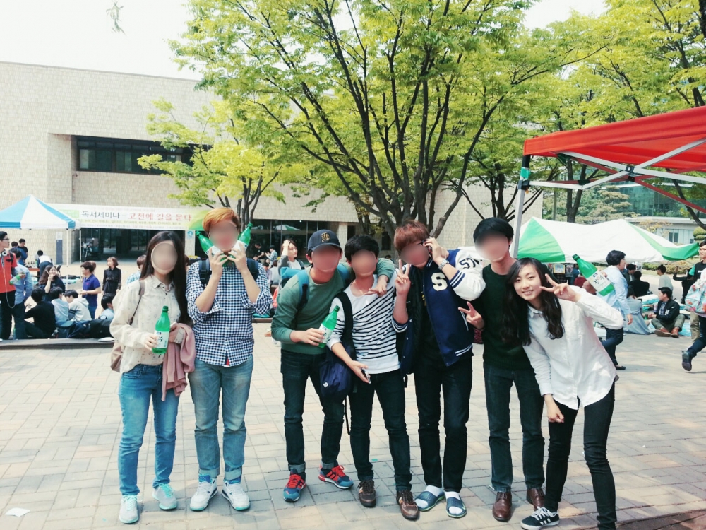 사진 설명 시작. 문화관 앞에서 막걸리를 들고 있는 다섯 명의 친구들 모습. ▲학교 주점 행사를 즐기는 안미진 씨와 친구들의 모습이다. 사진 설명 끝.