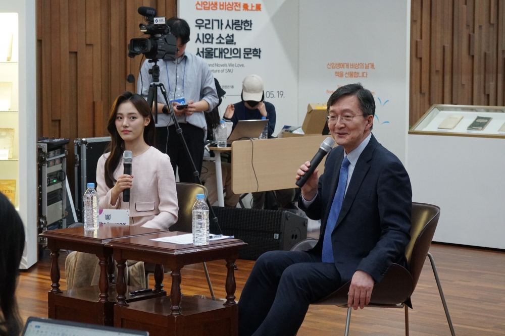 사진 설명 시작. 유홍림 총장이 의자에 앉아 있다. 유홍림 총장은 마이크를 쥐고 발언하고 있다. 유홍림 총장의 옆에는 사회자가 앉아 있다. 사진 설명 끝.